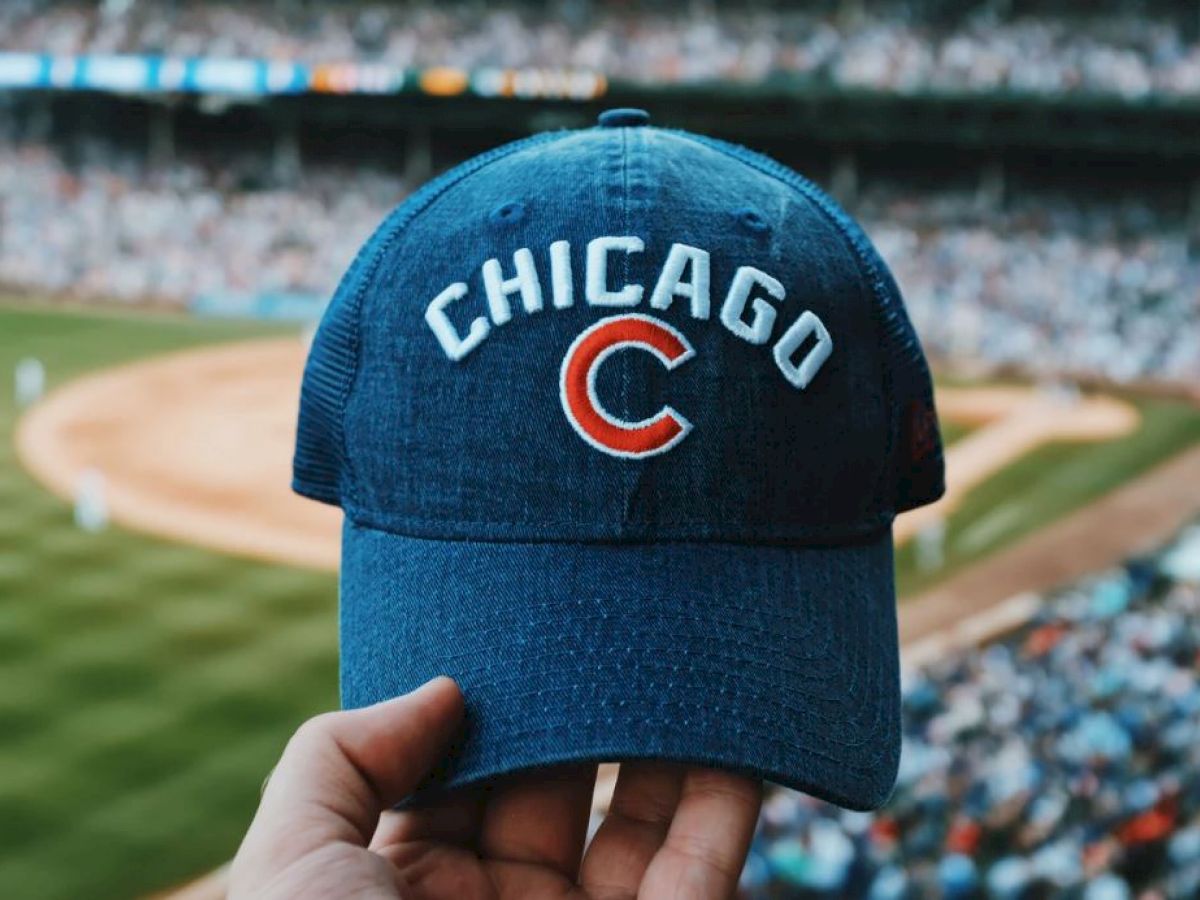 chicago cubs hat and stadium behind