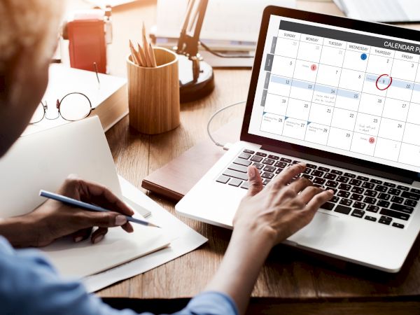 woman looking at calendar on computer