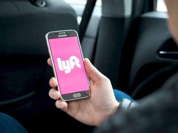 man holding phone with lyft app